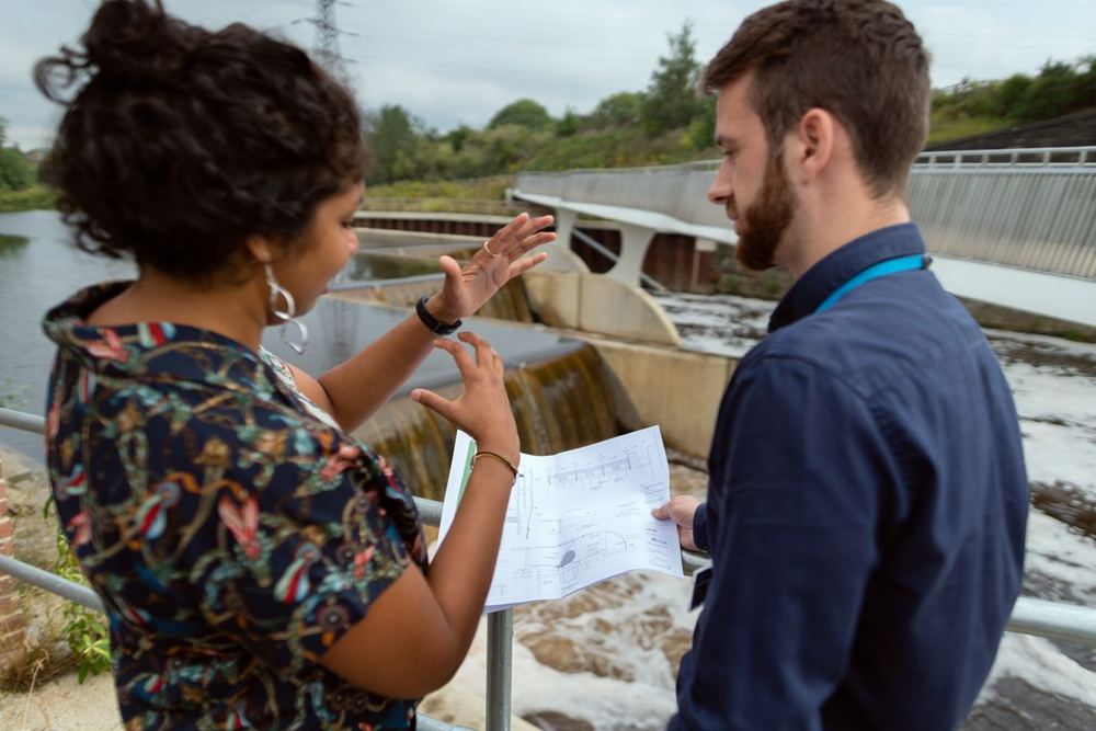 One person explaining how their operation runs while another takes notes