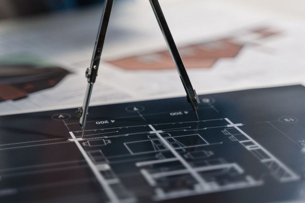 Drafting compass resting on a technical plan